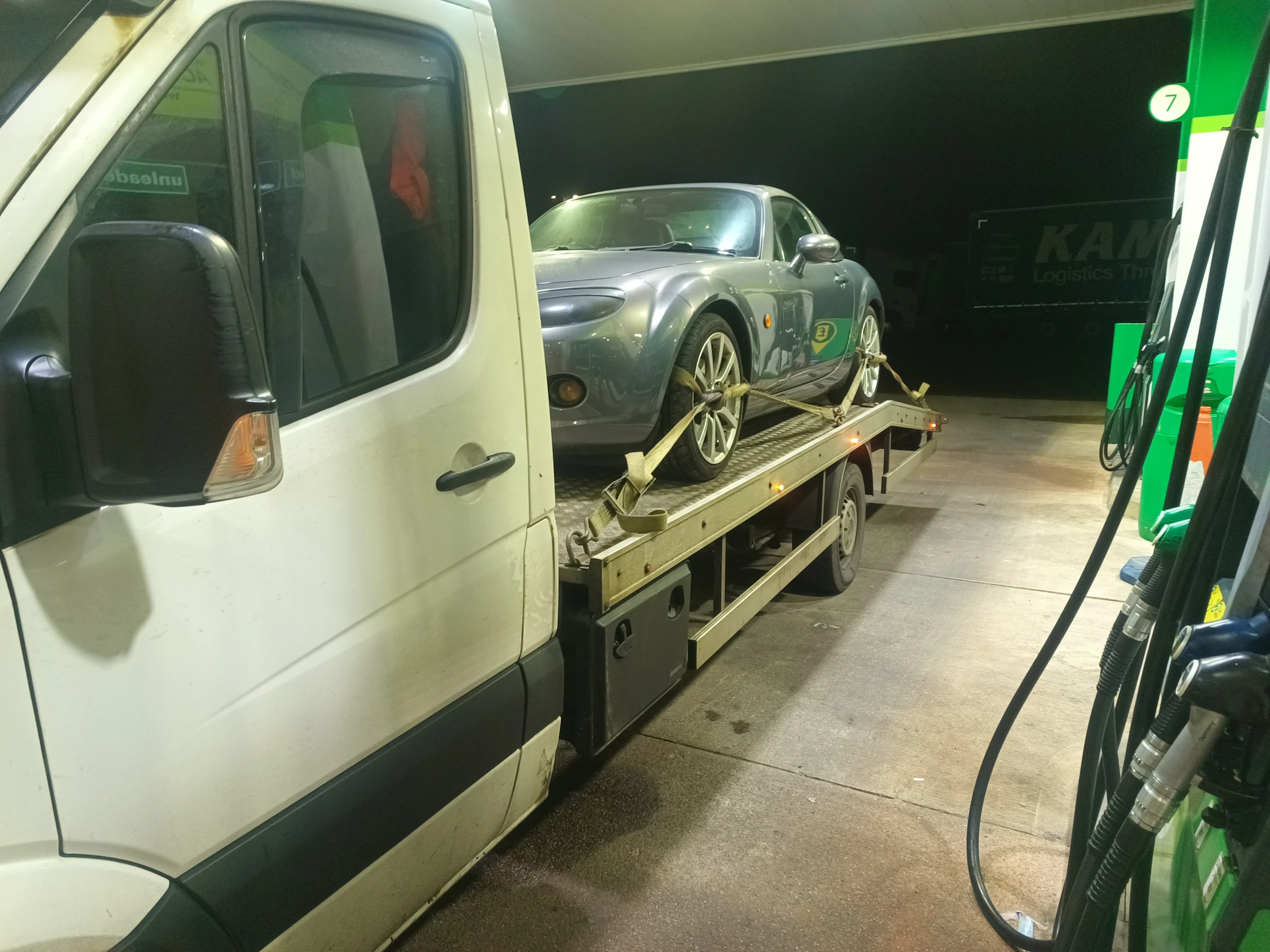 Car on a recovery truck at a fuel station