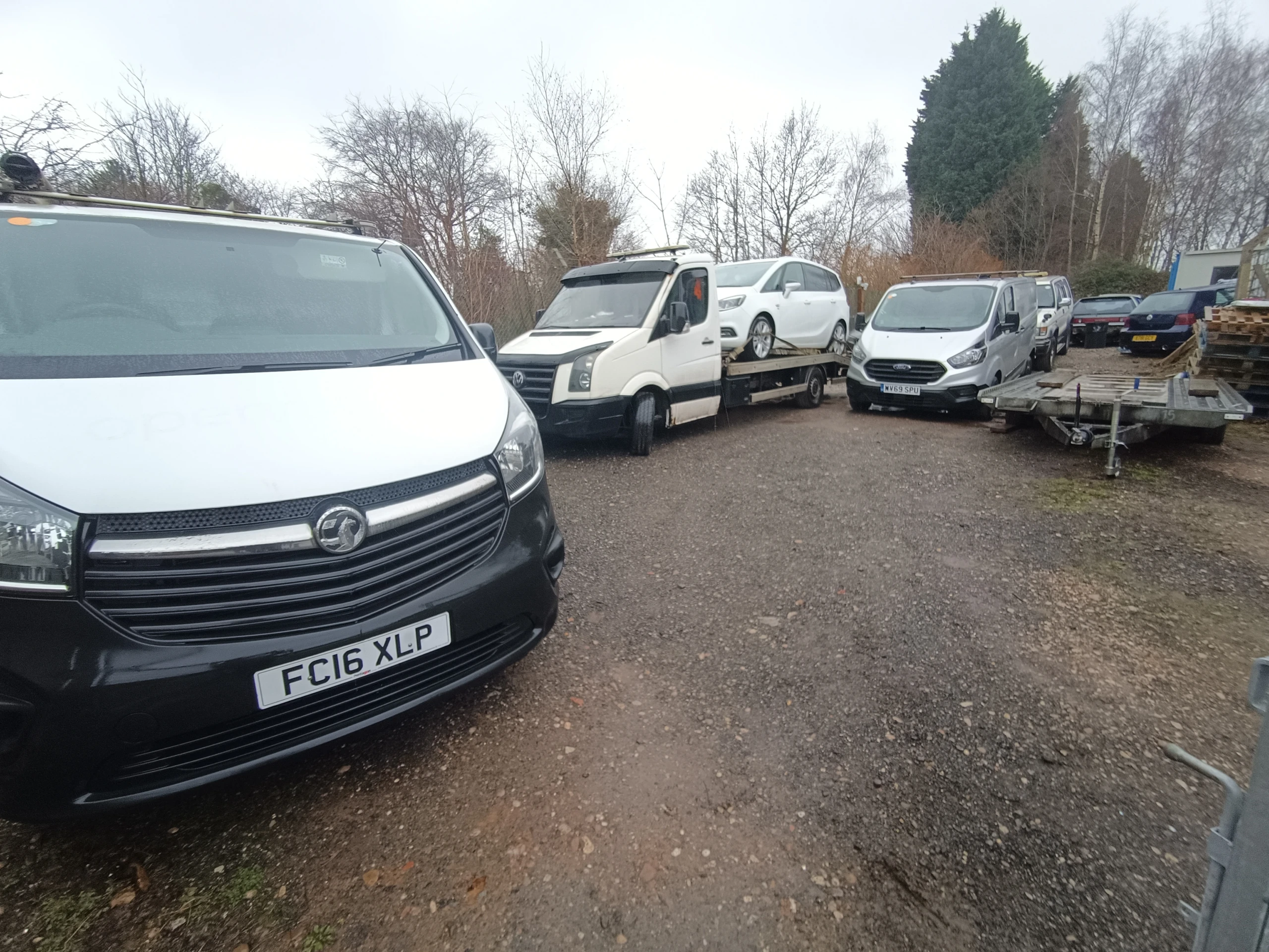 Commercial vans and a recovery truck at a vehicle depot