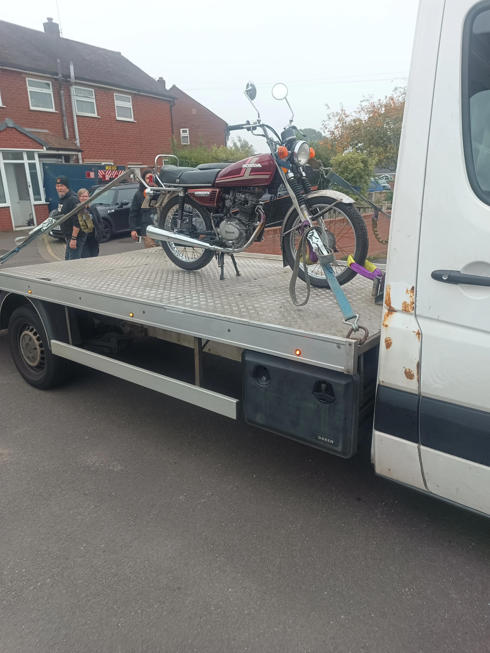 Motorcycle strapped to a flatbed truck for motorcycle recovery