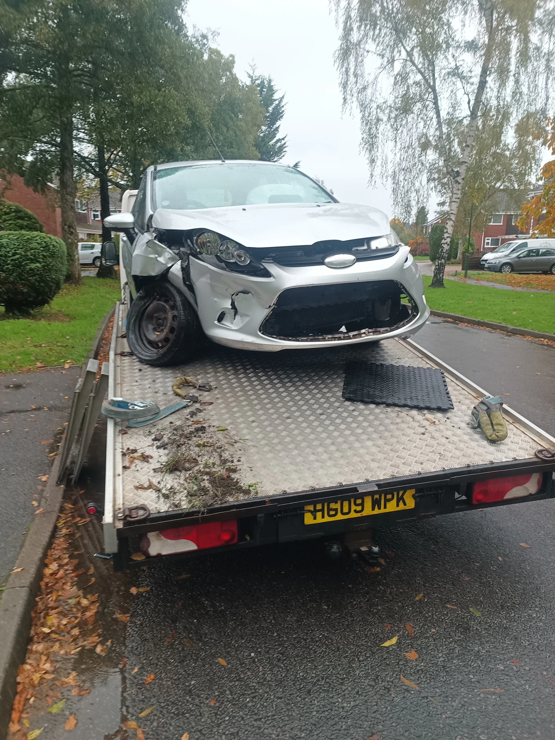 Accident-damaged car recovered on a flatbed truck in Birmingham
