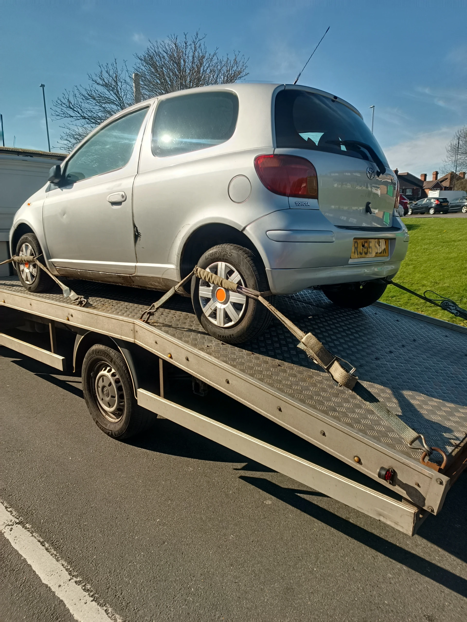 Small hatchback on a flatbed recovery truck